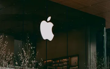 Светящийся логотип Apple на фасаде магазина в вечернем свете на фоне открытия предзаказов iPhone 18 Pro, Apple Watch Ultra 4 и AirPods 5 в Украине