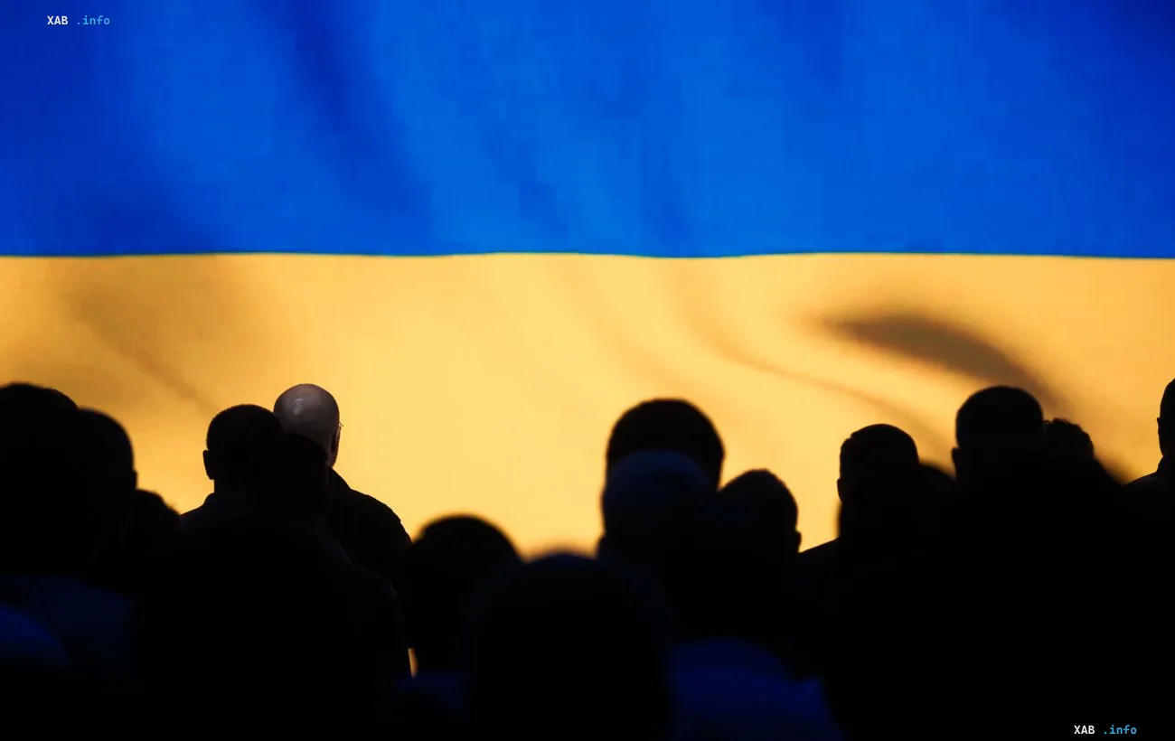 Силуэты людей на фоне украинского флага — возвращение граждан с оккупированных территорий