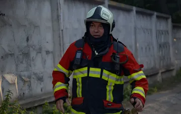 Rescue worker in protective gear and helmet with OKP marking at the scene of FPV drone attack in Shostkinsky district