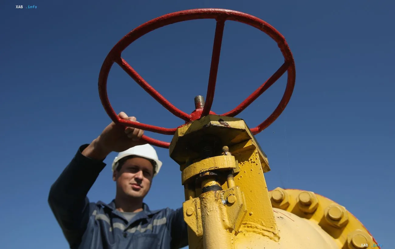 Работник газовой инфраструктуры Украины регулирует клапан на газовом оборудовании на фоне ясного неба в условиях профицита газа