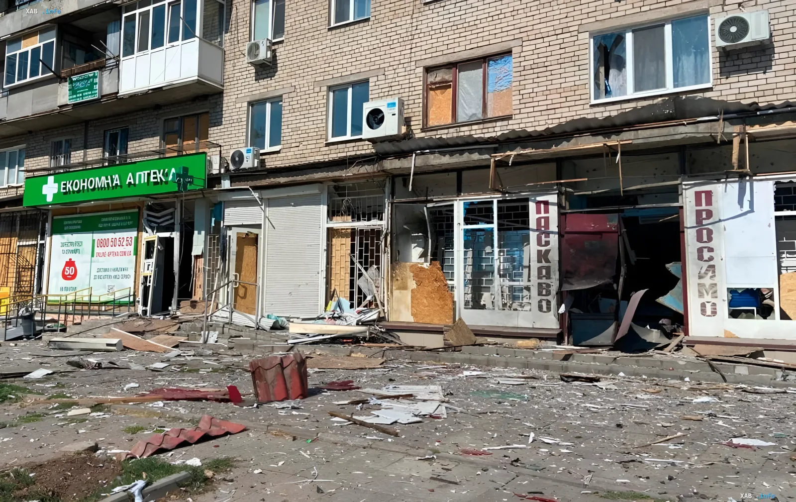 Пошкоджений фасад житлового будинку з зруйнованими вітринами магазинів після обстрілу в Дніпропетрівській області