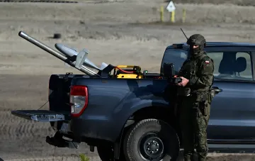 Военнослужащий НАТО управляет переносной системой ПВО на пикапе