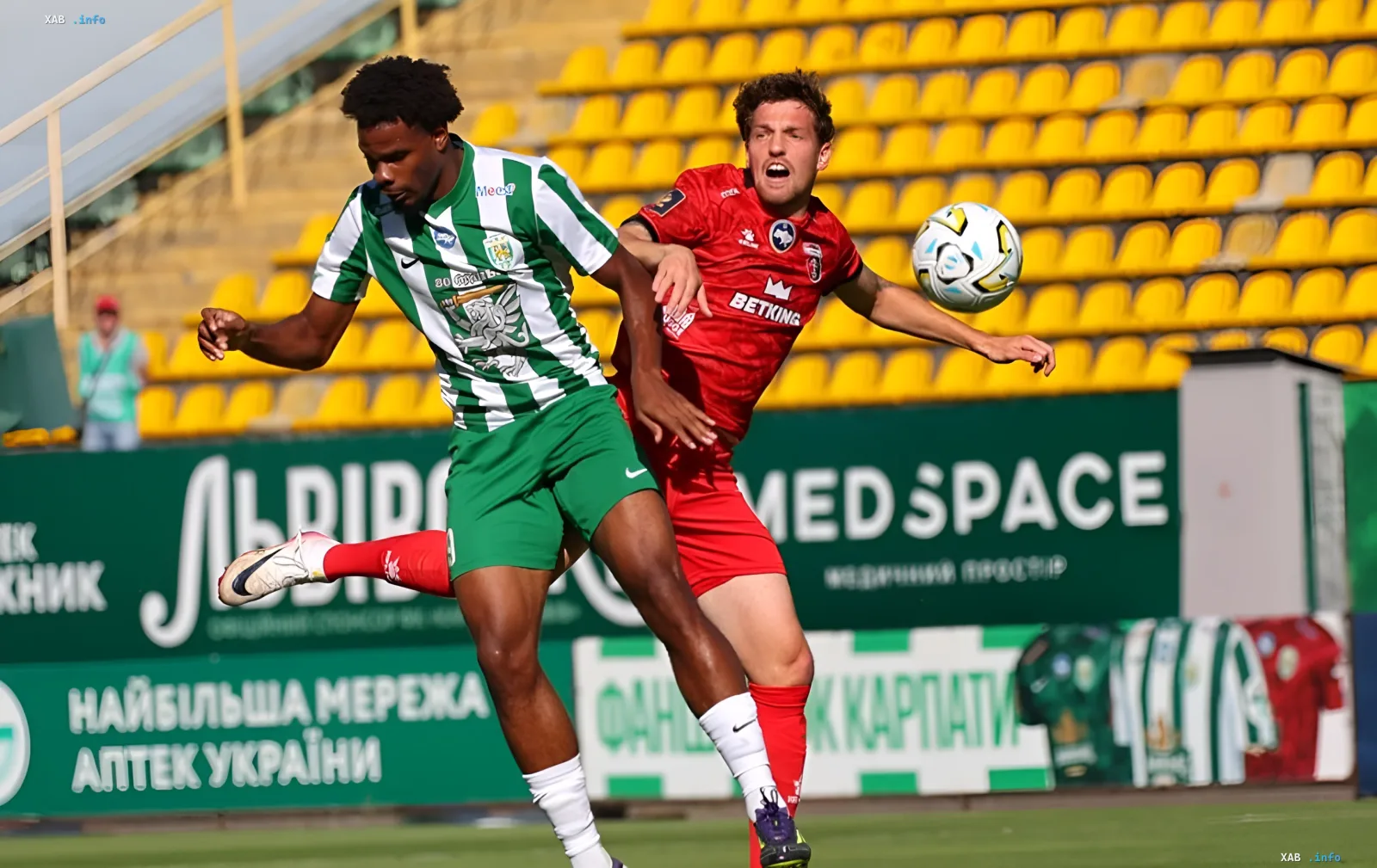Battle for the ball in the Karpaty vs Veres match: a Lviv player in striped kit against a footballer in red at the Lviv stadium