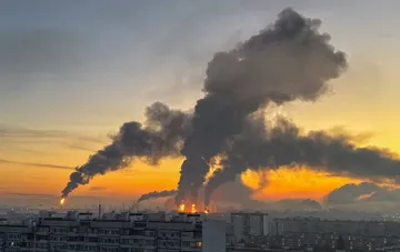 Schwarze Rauchwolken und Feuer über Moskauer Wohnblöcke bei Sonnenuntergang während des 'Pelican'-Angriffs — Drohne oder Ballistik