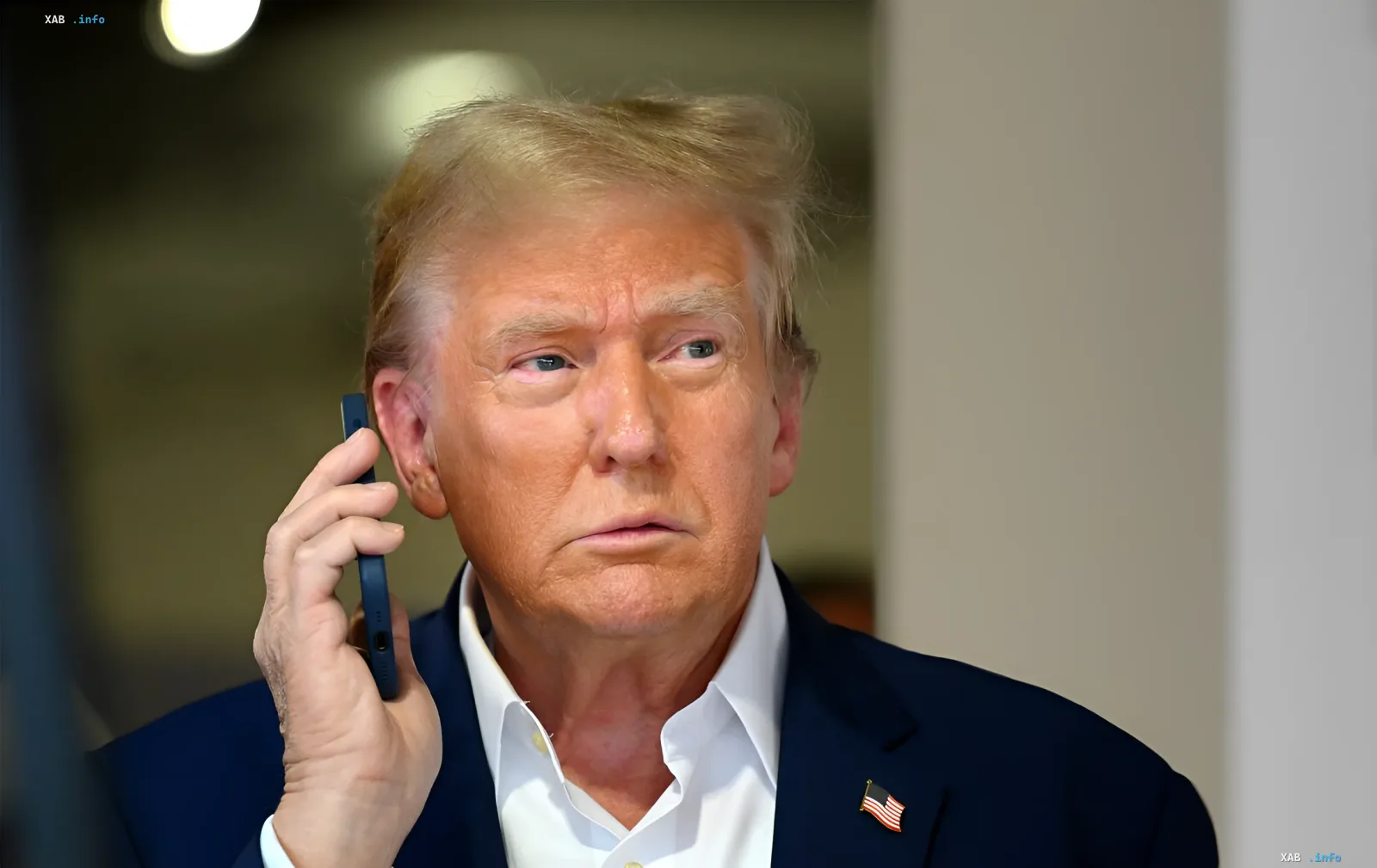 Дональд Трамп в деловом костюме с американским флагом на лацкане разговаривает по телефону на фоне создания «Сил ИИ» в США