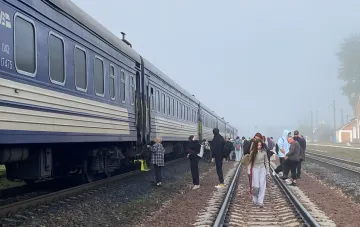 Пассажиры у остановившегося поезда на станции в тумане: УЗ разъяснила работу составов при жёлтой тревоге