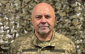 Alexander Hlywinsky in ukrainischer Tarnuniform vor einem Tarnnetz — Fußballkommentator meldet sich in das 7. Aufklärungsbataillon der ukrainischen Streitkräfte