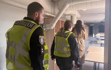 Ukrainian police officers inspect a university building in Kyiv following an incident where students were allegedly denied access to a shelter