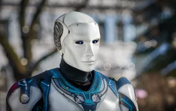 Humanoid combat robot with glowing blue eyes and armored body — military model for urban assault operations