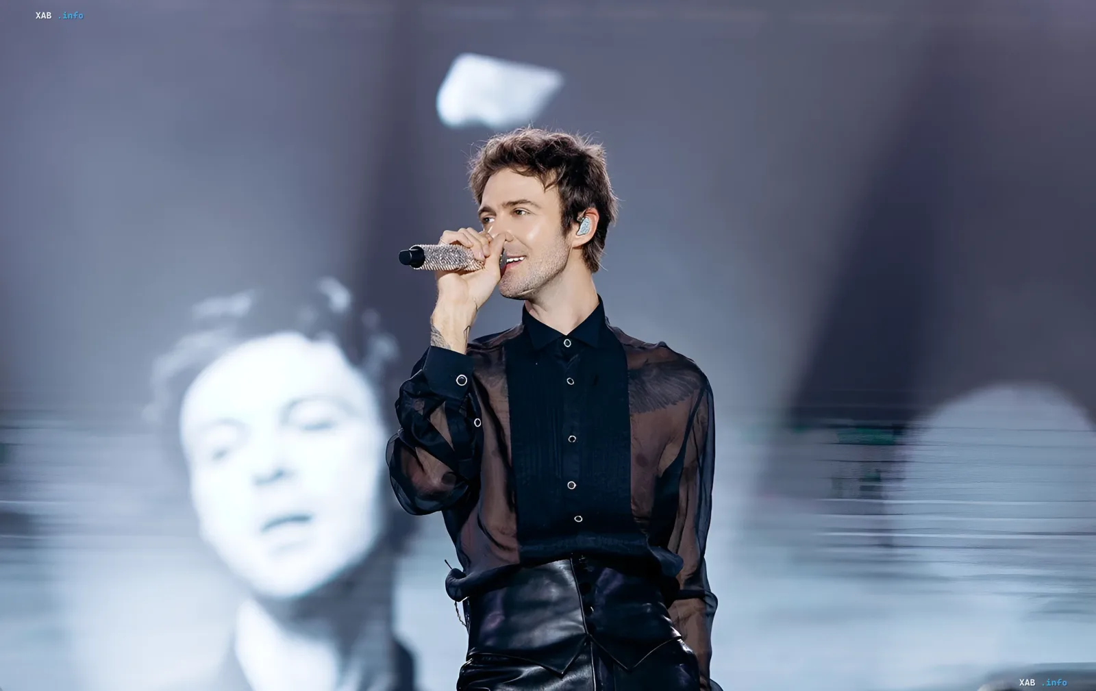 Max Barskih singing at a concert in Kharkiv, holding a sparkling microphone