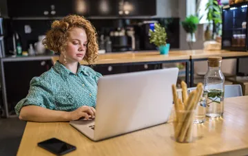 Female employee working on a laptop in an office: Ukraine's minimum wage rises to 9,546 UAH in the 2027 budget