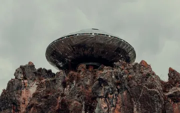 Disc-shaped UFO hovering over a rocky cliff — illustration of the Pentagon's declassified documents on anomalous objects