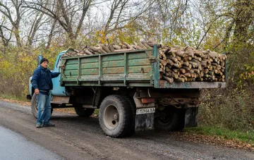 Грузовик с прицепом, загруженный дровами, на лесной дороге в Украине на фоне рекордного спроса на древесное топливо