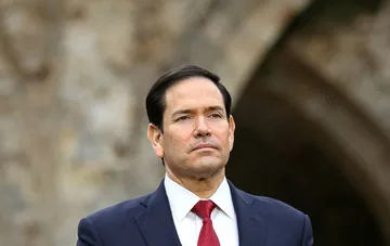 US Secretary of State Marco Rubio in a formal suit against a stone wall backdrop, in the context of Washington's complaint to Ukraine over attacks on US-linked vessels