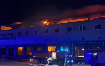 Нічний пожежа на розподільному центрі «Сільпо» в Одесі після удару: полум'я над дахом складу та пожежники на місці