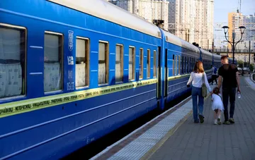 Passenger carriages of a UZ train at a station platform waiting for departure