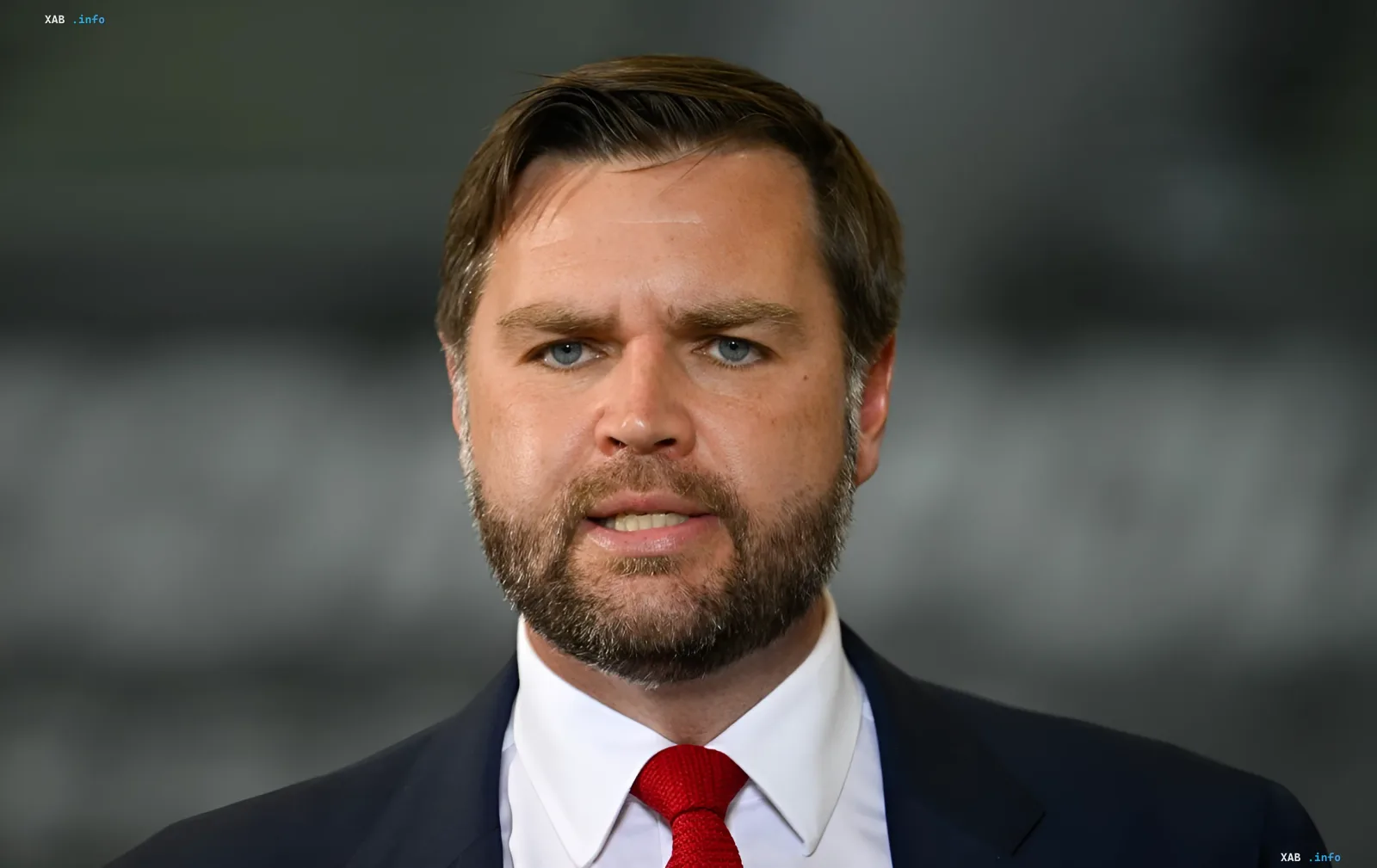 JD Vance in a dark suit with a red tie against a gray backdrop — statement on the inevitable Ukraine war settlement and the Trump-Zelensky meeting