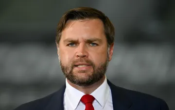 JD Vance in a dark suit with a red tie against a gray backdrop — statement on the inevitable Ukraine war settlement and the Trump-Zelensky meeting