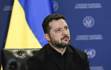 Volodymyr Zelensky after meeting with Donald Trump against the backdrop of the Ukrainian flag and an international organization emblem