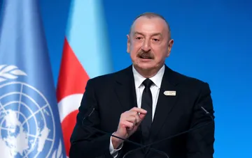 Президент Азербайджана Ильхам Алиев на фоне флага страны и ООН во время COP29, на фоне решения о помиловании французского бизнесмена Раяна
