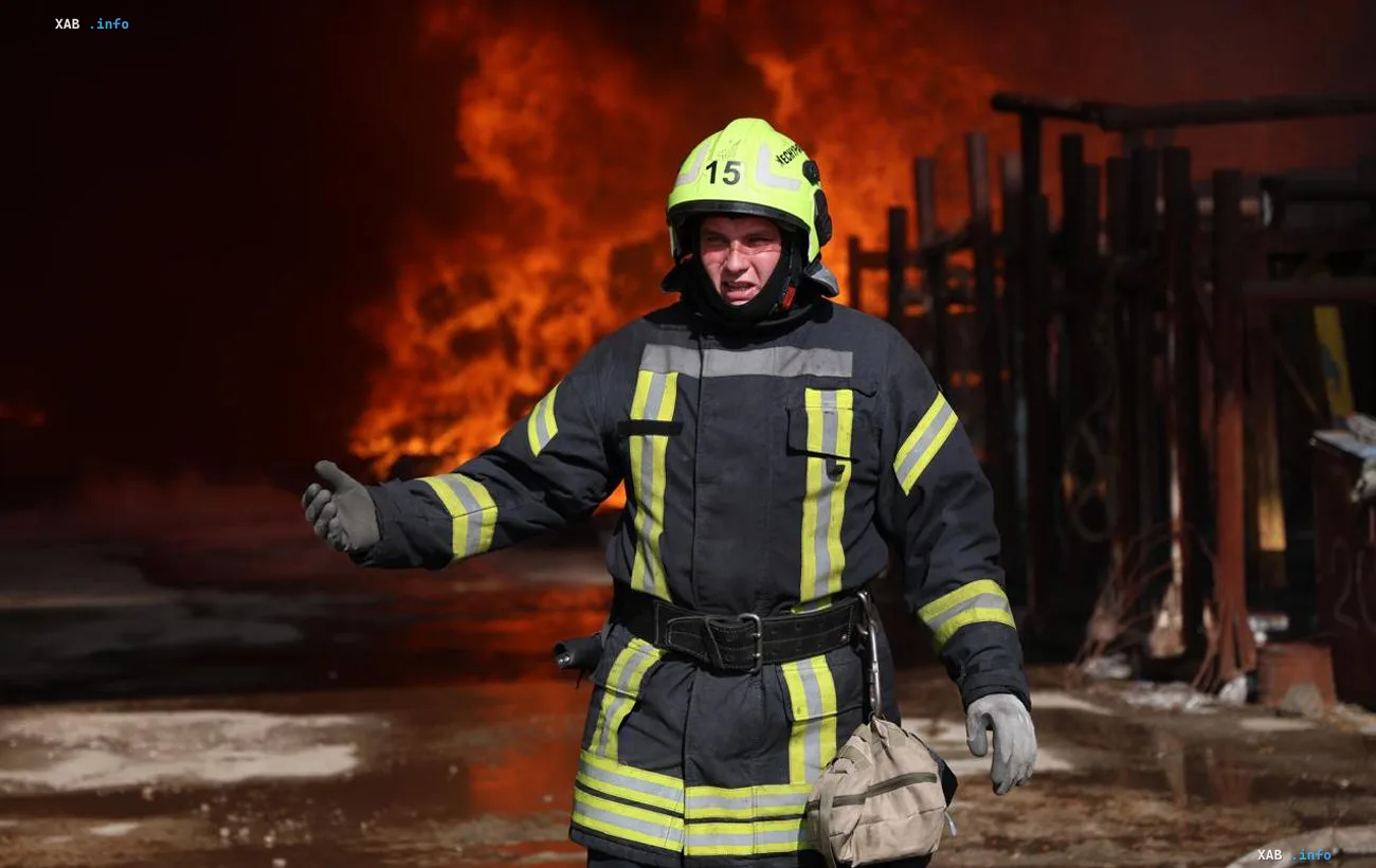 Firefighter in protective gear in front of flames after drone strikes on gas stations in Kyiv