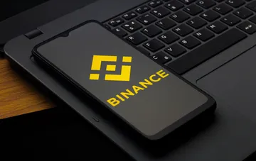 Binance logo on a smartphone screen: the crypto exchange drops the USDT/UAH pair and hryvnia withdrawals until the end of September