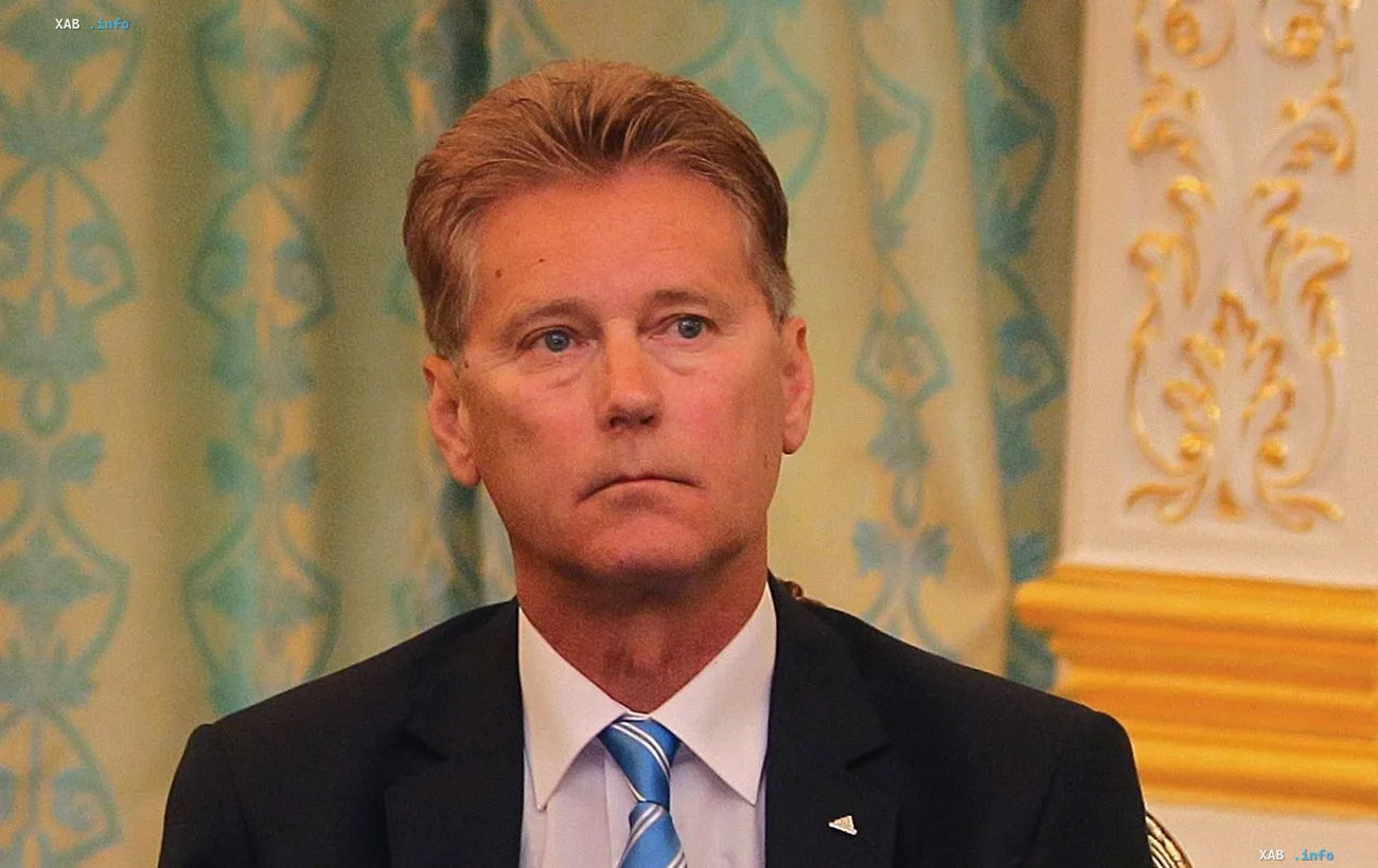 Leonid Buryak in a business suit against a decorative interior backdrop — coach reflects on the Euro 2004 qualifying campaign