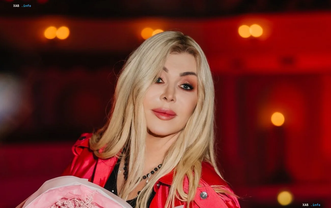 Iryna Bilyk in a new look: platinum hair, red jacket, and a bouquet of roses
