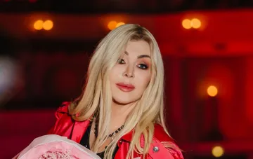 Iryna Bilyk in a new look: platinum hair, red jacket, and a bouquet of roses