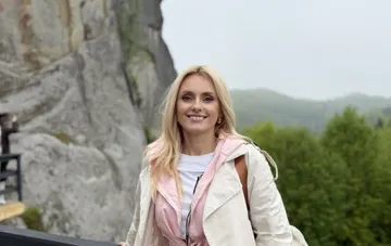 Iryna Fedishyn at 32 weeks pregnant in a tender look against a mountain landscape