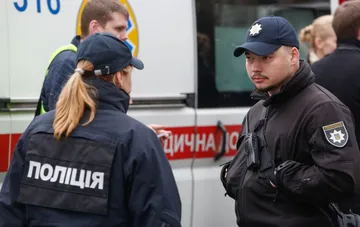 Полицейские на месте последствий атаки на Киев 23 сентября: правоохранители координируют действия у служебного автомобиля
