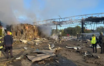 Aftermath of a drone attack in Kyiv: firefighters extinguish a damaged building with a collapsed metal frame