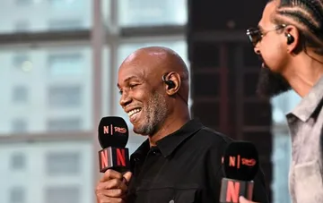 Lennox Lewis smiles during an ESPN interview, commenting on his chances in a hypothetical fight against Alexander Usyk