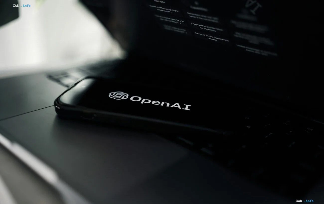 Smartphone displaying the OpenAI logo on a laptop — announcement of updated GPT-6 Sol and Luna models