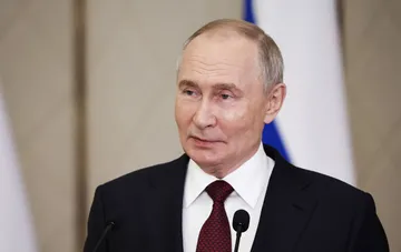Wladimir Putin bei einer offiziellen Ansprache vor Mikrofonen vor dem russischen Flaggenhintergrund im Kontext der Bereitschaft zu einem Treffen mit Trump