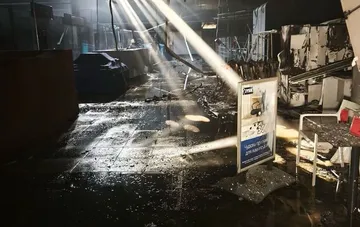Destroyed JYSK store in Zaporizhzhia after a Russian strike: firefighters spray water on smoldering spots, soot-covered walls and debris on the floor
