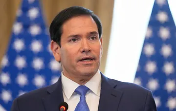 Marco Rubio at a press conference in front of American flags, commenting on negotiations to end Russia's war against Ukraine