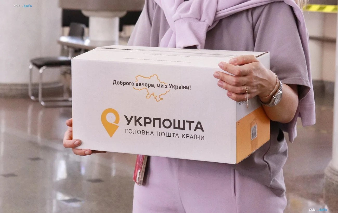 A person holds a box with the Ukrposhta logo at a city post office when sending a parcel under the priority rule