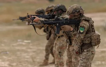 Ukrainian soldiers with assault rifles in formation in the Donbas, in the context of strikes on UAV command posts and the Rubicon unit's depot on 22–23 September