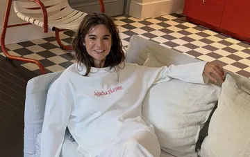 Dasha Katsurina in einem weißen Langarmshirt mit Agatha-Playing-Aufschrift im neuen Showroom-Interieur in Kiew