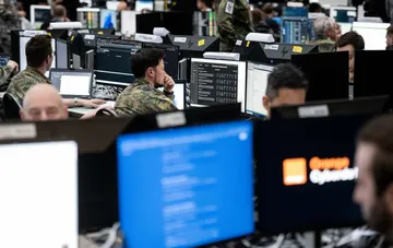 NATO-Kyberabwehr-Operatoren an Arbeitsstationen mit Bedrohungsüberwachungssystemen vor dem Hintergrund russischer Hybridangriffe