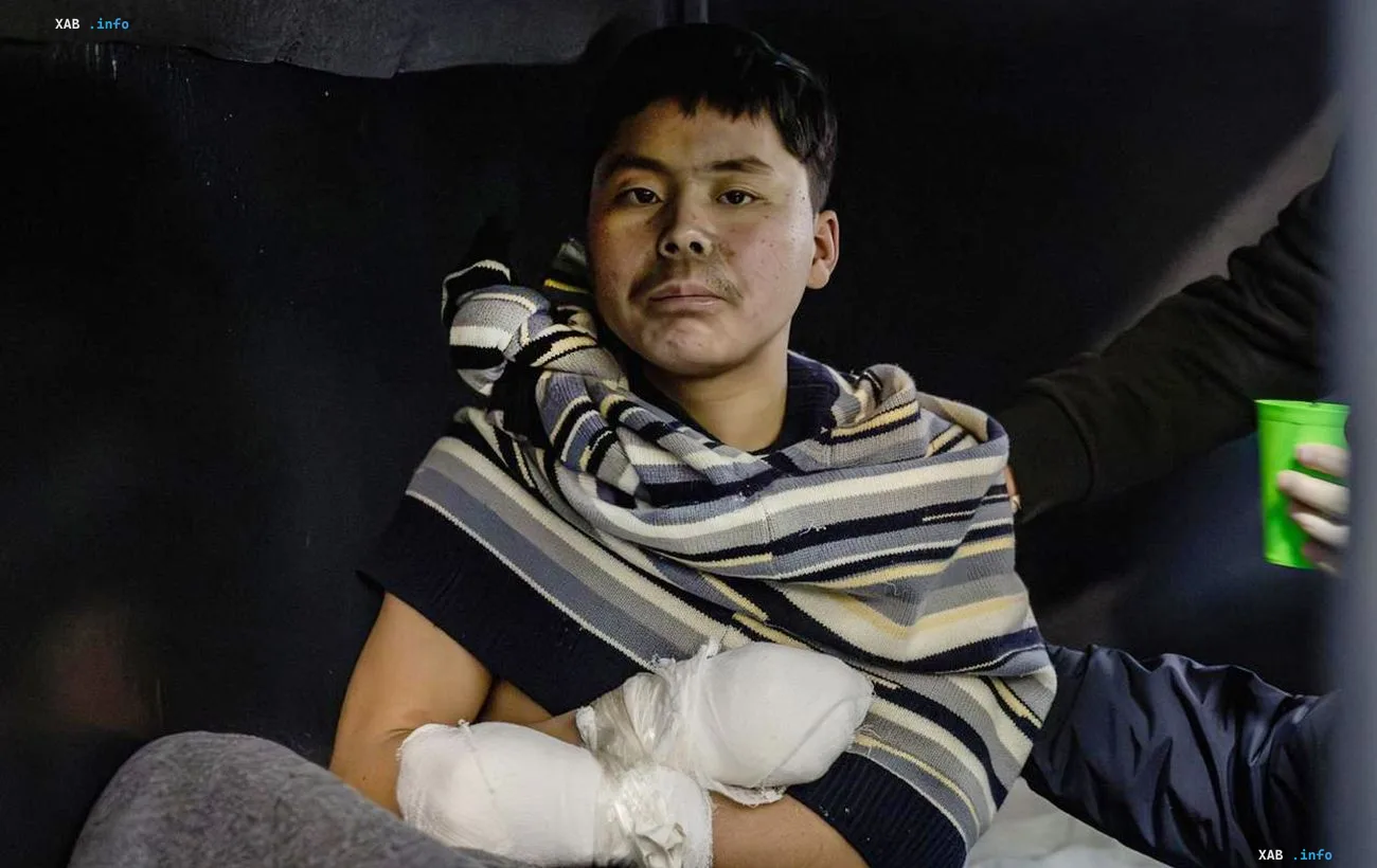 Injured North Korean soldier with bandaged wrists and facial wounds wrapped in a striped blanket, handed over to South Korea per Zelensky's UN statement