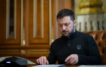 Владимир Зеленский за столом с документами перед интервью WSJ о допущенных за годы войны ошибках