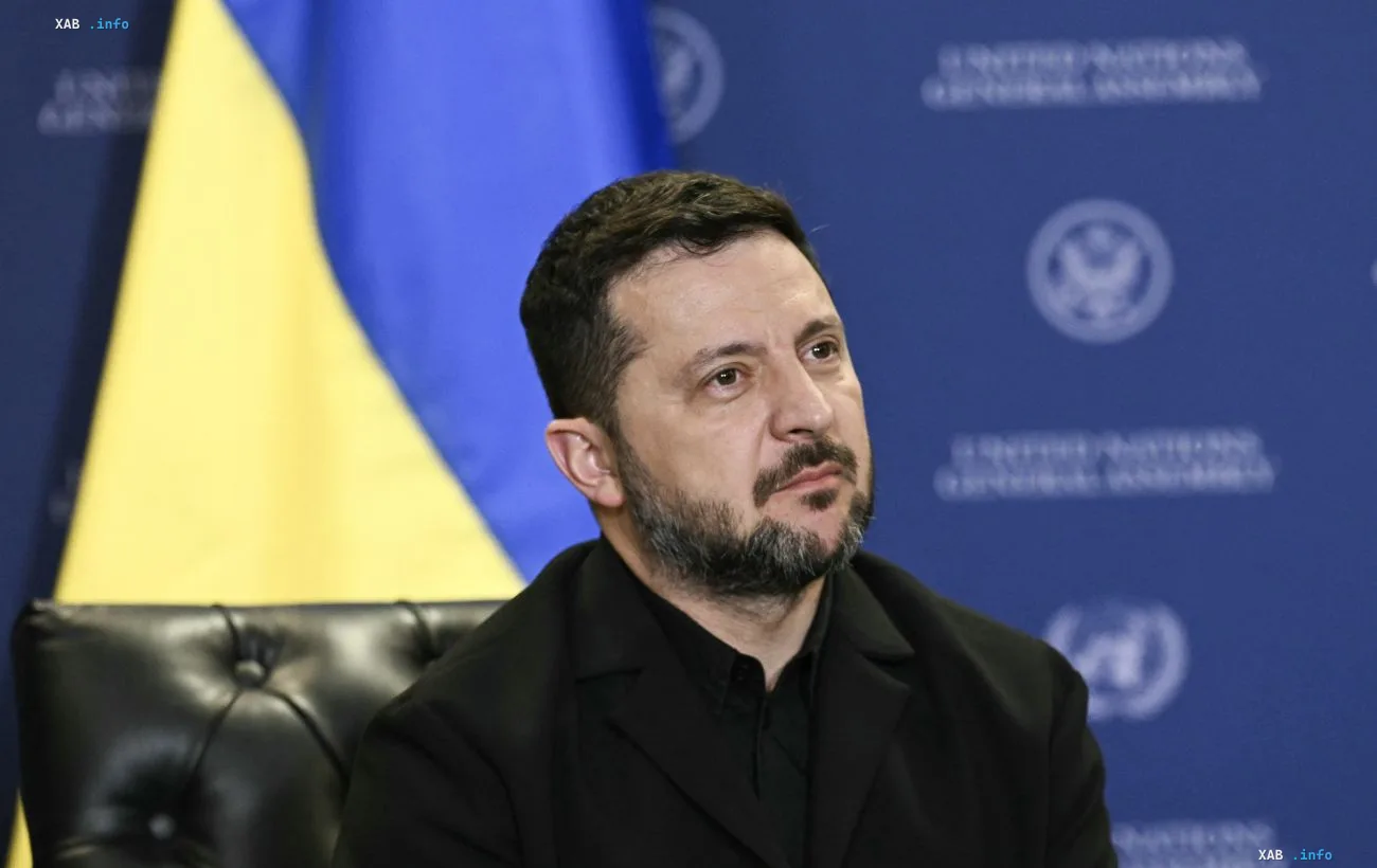 Владимир Зеленский на фоне украинского флага и официального баннера во время обсуждения плана деэскалации с США