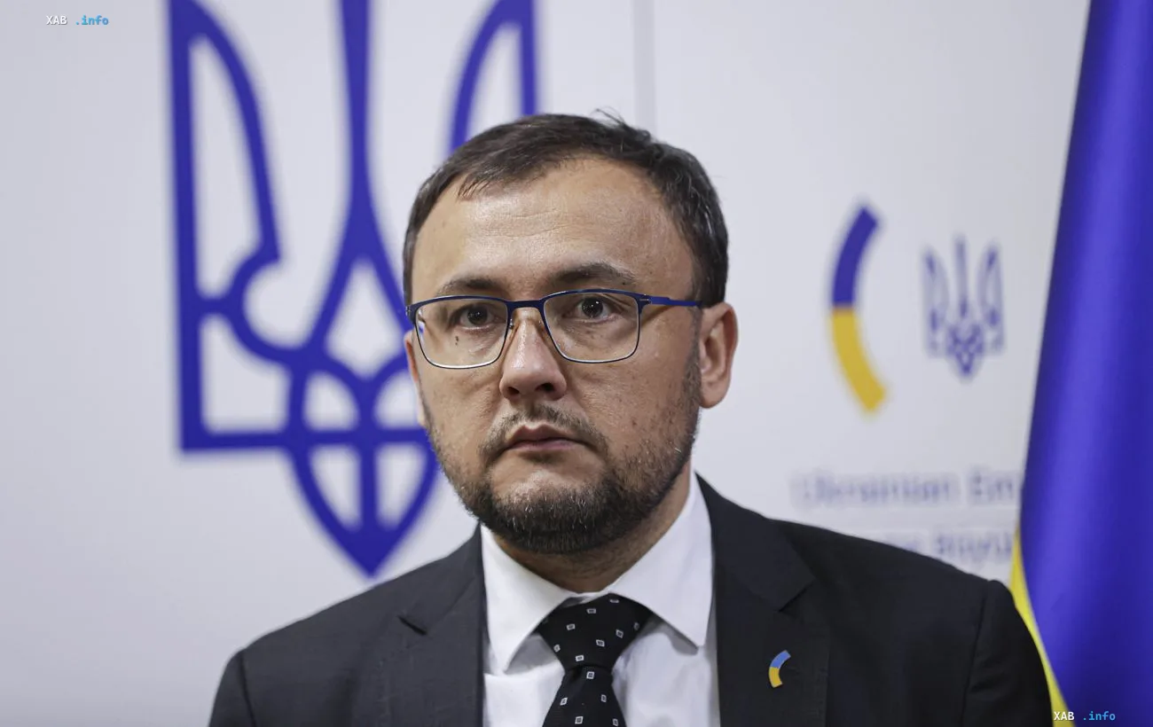 Посол Украины в Польше на фоне государственного герба и флага во время брифинга о росте числа нападений на украинцев