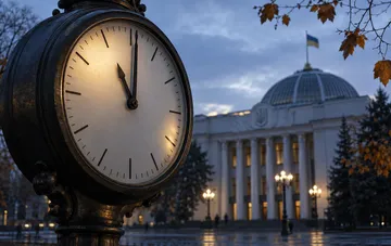 Уличные часы на фоне здания Верховной Рады Украины в осенний вечер — перевод часов и переход на зимнее время в 2026 году