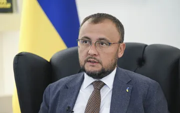 Посол Украины в Польше на фоне украинского флага во время интервью о двусторонних отношениях