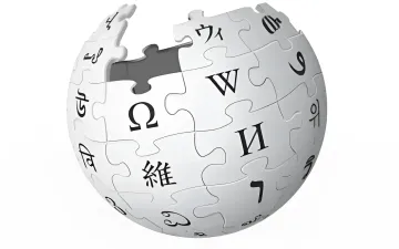 Wikipedia logo and interface on a smartphone and laptop screen next to AI servers