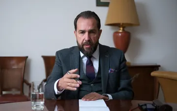 Польский флаг на фоне зданий и украинские беженцы
