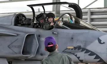 Queen Suthida of Thailand next to a Gripen fighter jet